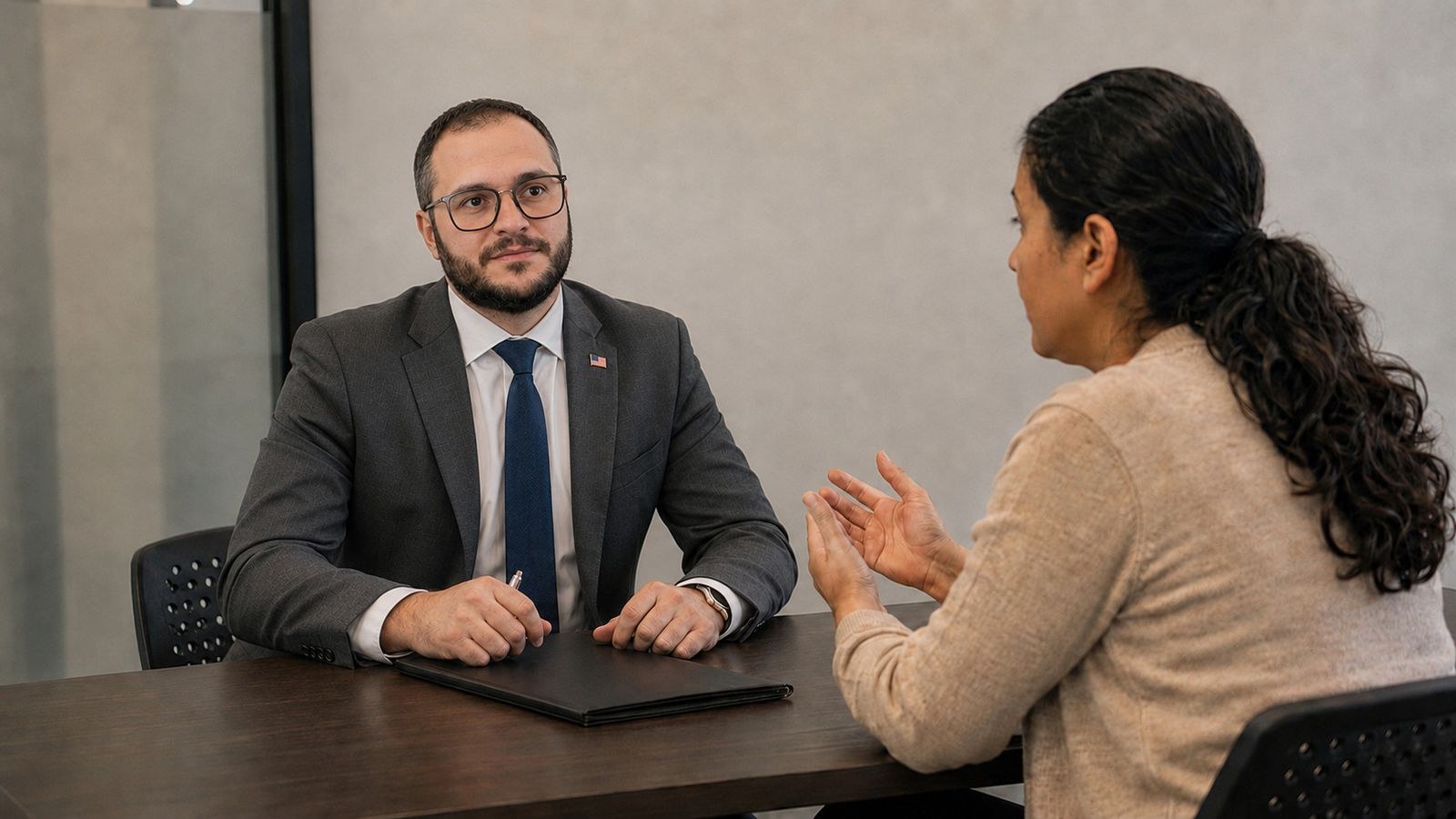 Mikhail Usher listening to a client across a table